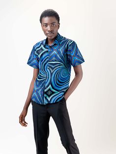 Our Mankon short Sleeve shirt is made of 100% cotton and features a relaxed, fitted silhouette. The African print on this lightweight shirt is subtle but bold, and the colors are beautiful. It's the perfect shirt for any occasion! Description 100% Cotton African Print Wax Short sleeves Front button Top length is 20 inches Made in Cameroon Fabric from Benin Care instructions hand wash cold iron on wrong side hang to dry do not bleach Printed Relaxed Fit Hawaiian Shirt, Printed Relaxed Fit Hawaiian Shirt Short Sleeve, Blue Printed Cotton Camp Shirt, Short Sleeve Shirt With Graphic Print, Blue Cotton Collared Camp Shirt, Blue Collared Cotton Camp Shirt, Fitted Cotton Shirt With Graphic Print, Fitted Graphic Print Cotton Shirt, Relaxed Fit Hawaiian Shirt With Graphic Print