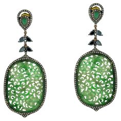 Gorgeous oval-shaped carved jade dangle earrings with emerald and spinel accents and shimmering diamonds. 18k:1.71g, Diamond:3.5ct, Silver:20.65gm, Emerald:0.7ct, Jade-41.85, Spinel-4.10 Size: 90X36MM" Luxury Green Oval Earrings, Green Diamond Pierced Earrings, Elegant Green Earrings With Rose Cut Diamonds, Green Oval Earrings With Diamond Accents, Gemstones Earrings, Gold Fashion Jewelry, Amazing Earrings, Black Earrings Dangle, Carved Jade