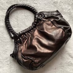 Great Used Condition. Telescope Bag By Christian Louboutin In Black With Bronze Metallic Finish And Signature Red Interior (Listed As Black/Gold). Luxe Designer Statement Piece. Slouchy Hobo Shoulder Handbag With Antiqued Metallic Patina Rubbed Leather, See Video. Dual Shoulder Straps With Chain Link Interior And Ruffle Detail. Top Zip Closure. Red Satin Lining. Single Pocket At Interior Wall With Additional Zip Pocket And Decorative Red Bottom Silhouette Zipper Pull. Note: Light Wear Throughout With Rubbing And Leather Lightening, Scratching To Hardware And Bottom, & Small Seam Pull At Interior Lining Corner, See Photos. See Photos For Measurements. Louboutin Bags, Fur Purse, Red Louboutin, Red Bottom, Hobo Shoulder Bag, Red Interior, Shoulder Bag Black, Red Bottoms, Medium Tote