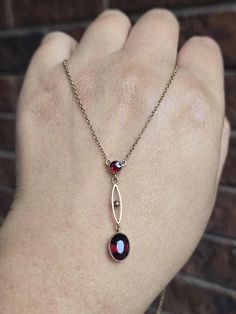 An antique Victorian 9ct yellow gold ornate garnet lavalier necklace. It measures approximately 16.5 inches long and weighs 2.97g.  The garnet drop is attached to a simple dainty rolo chain, therefore it is not removable. The necklace has a functional spring ring clasp which is stamped 9ct, though the hallmark has partially worn out and hard to identify.  The larger garnet stone measures 9x6.5cm and the smaller stone is 4x4mm. Both stones are in excellent condition with no damage.  This beautifu Antique Garnet Pendant Necklace, Yellow Gold Garnet Necklaces With Oval Shape, Yellow Gold Oval Garnet Necklace, Victorian Gemstone Oval Pendant Necklace, Victorian Gemstone Necklace With Oval Pendant, Victorian Oval Pendant Necklace With Gemstone, Victorian Oval Pendant Gemstone Necklace, Antique Garnet Birthstone Jewelry, Victorian Garnet Necklace Gift