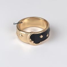 a gold ring with black leather and stars on the side, in front of a white background