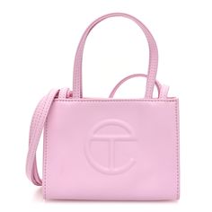 This is an authentic TELFAR Vegan Leather Small Shopping Bag in Bubblegum. This mini tote is constructed of faux leather in pink with the iconic raised Telfar logo at the front. The shoulder bag has thin pink handles and a long crossbody strap. The bag opens to a pink fabric interior. Telfar Logo, Pink Handles, Green Highlights, Pink Tote, Mini Tote, Pink Fabric, Bubble Gum, White Bag, Pink Bag