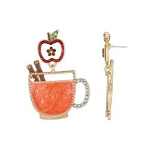 a pair of earrings with an apple on top and a cup in the middle, sitting next to each other