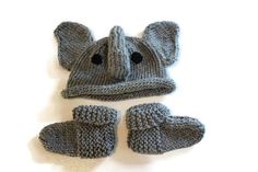 an elephant hat, mittens and booties are laying on the floor