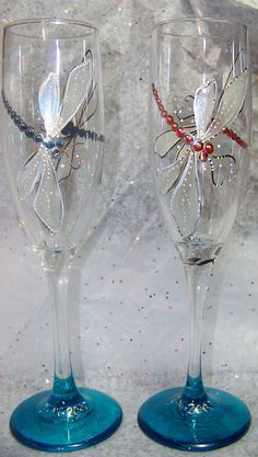 two wine glasses with dragonfly designs on them