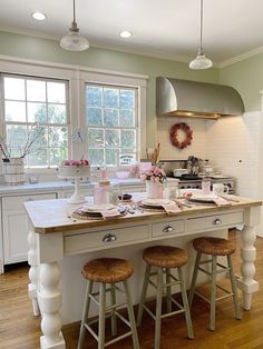 a kitchen island with three stools in front of it and an oven behind it