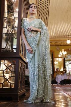 Sage green net saree with abstract geometric and floral embroidery in cutdana, beads and sequins with tassels on the pallu. Paired with a padded floral embroidered choli.
Components: 2
Pattern: Embroidered
Type Of Work: Cutdana, Sequin, Bead
Neckline: Leaf
Sleeve Type: Half
Fabric: Net
Color: Green
Occasion: Sangeet, Reception - Aza Fashions Green Chanderi Pre-draped Saree With Intricate Embroidery, Transitional Green Saree With Intricate Embroidery, Pista Green Saree With Intricate Embroidery, Festive Pista Green Blouse Piece With Intricate Embroidery, Pista Green Georgette Saree With Intricate Embroidery, Designer Pista Green Saree With Intricate Embroidery, Designer Wear Pista Green Saree With Intricate Embroidery, Pista Green Saree With Intricate Embroidery For Reception, Green Pre-draped Saree With Intricate Embroidery For Wedding