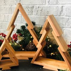 three wooden christmas trees with lights on them