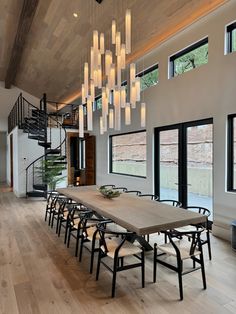 a dining room table with six chairs and a chandelier hanging from the ceiling