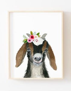 a painting of a goat with flowers on its head is mounted in a wooden frame