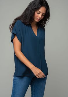 An unbelievably soft and silky hand feel elevates this classic short sleeve top. Featuring a cuffed sleeve, a flattering v-neckline, and a flowy, relaxed fit. Try it loose over jeans for a cool and casual vibe, or tuck it into trousers for a polished look. Silky crepe Relaxed fit V-neckline Short cuffed sleeve Banded collar Split neckline Bohemian top Model is 5'9, wearing a size S.Style: I-13140W-RPL Bohemian Top, Midnight Blue Color, Cuffed Top, Cuffed Sleeve, Bohemian Tops, Band Collar, Top Model, Polished Look, Cuff Sleeves