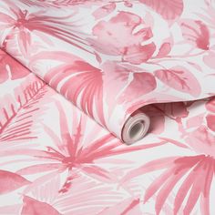 a pink and white floral wallpaper with large leaves on the bottom half of it