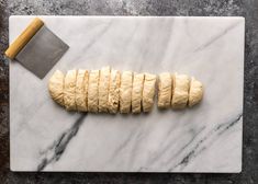 a marble cutting board topped with dough and a rolling pin