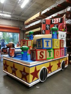 a large toy train with lots of blocks on the front and sides in a warehouse