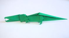 an origami green dragon sitting on top of a white table