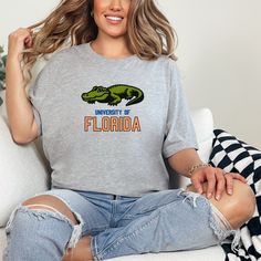 Show your support for the Florida Gators with this unisex Florida T-Shirt. Made with 100% Airlume combed and ring-spun cotton, this lightweight tee is perfect for active and leisure wear. The retail fit and classic crew neckline make it versatile for casual and semi-formal settings. This Florida Gators shirt is a must-have for any UF fan or Florida local. Product features - Made with 100% Airlume combed and ring-spun cotton for breathability - Retail fit suitable for casual and semi-formal wear Florida Tshirt, College Merch, Florida Shirt, Semi Formal Wear, University Of Florida, Florida Gators, Leisure Wear, Unisex Design, Formal Wear