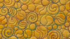 a close up view of yellow and green circles on a piece of material that has been stitched together