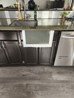 a kitchen with wood flooring and stainless steel appliances in the middle of the countertop