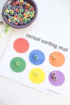 cereal sorting mat with buttons and beads next to a bowl of cereals on a table