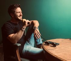 a man sitting in a chair with his hand on the table