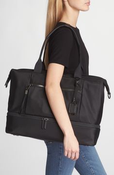 Stay organized with this versatile duffle bag featuring two interior compartments with a quick top zipper that makes it ideal for long weekends and work trips. This bag includes Tumi Tracer®, an exclusive, complimentary program that helps reunite lost or stolen bags with their rightful owners using a one-of-a-kind 20-digit number affixed to the bag Top carry handle; removable, adjustable crossbody strap Quick-access phone pocket; media pocket; water-resistant water bottle pocket; leather card po Luxury Travel Bag With Zipper Pocket For Daily Use, Versatile Rectangular Luggage With Zipper Pocket, Elegant Large Capacity Duffle Bag For On-the-go, Zipper Closure Duffle Bag For On-the-go, Modern Black Duffle Bag For Travel, Modern Black Duffle Bag For Trips, Modern Luggage With Zipper Pocket For Trip, Luxury Duffle Bag With Zipper Pocket For Daily Use, Modern Travel Bag With Zipper Pocket For Trips