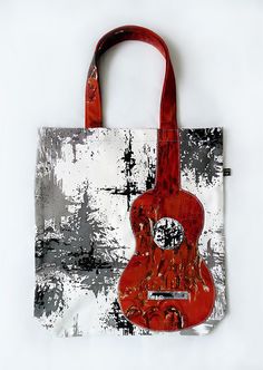 a red guitar bag sitting on top of a white table next to a black and white wall