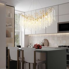 a modern kitchen with an island and chandelier hanging from the ceiling above it