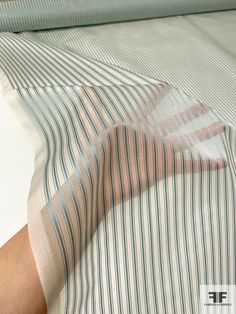 a person laying in bed with a striped shirt on