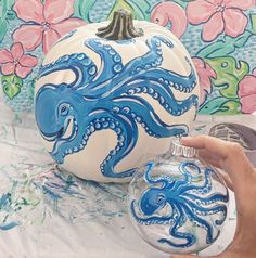 a hand painted pumpkin with an octopus on it and a blue octopus ornament