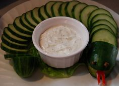 cucumbers and dip are arranged on a plate