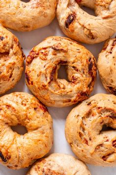 freshly baked bagels are arranged on a white surface