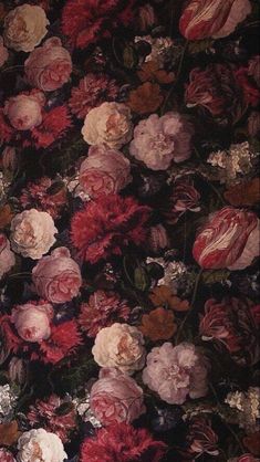 a bunch of flowers that are sitting on a tablecloth with red, pink and white flowers all over it