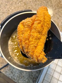 a fried fish is being cooked in a pot