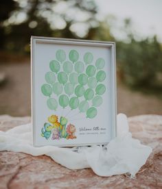 a photo frame sitting on top of a rock next to a white cloth covered ground