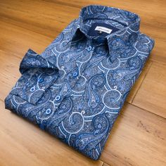 A charming multi-tonal blue paisley on a steel grey background. Blue paisley prints have consistently been some of the most popular designs of Grenouille shirts and it's easy to see why; elegant, understated and incredibly easy to match with. We kept the overall design for this shirt simple, with accessories and piping in matching blue shades. Made in our relaxed fit style and with a 2 button adjustable size cuff; no darts, but very slightly shaped for a feminine look. Details: - 100% cotton pop Classic Blue Printed Shirt, Classic Blue Printed Tops, Blue Paisley Print Long Sleeve Shirt, Blue Cotton Tops With Paisley Print, Classic Blue Paisley Print Tops, Fitted Blue Printed Shirt, Blue Fitted Top With Paisley Print, Fitted Blue Top With Paisley Print, Classic Paisley Print Patterned Tops