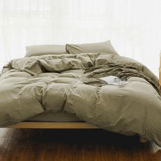 an unmade bed sitting on top of a wooden floor