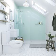 a white bathroom with skylights above the toilet and shower stall is shown in this image