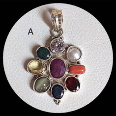 Genuine 925 Sterling Silver Navratan Pandent  Gemstone - Ruby , Emerald , Blue Sapphire, Yellow Sapphire, Hessonite, Cats Eye, Coral, Pearl, Cubic Zircona.  Stones setted - 9 pieces Quantity - 1 PC. No. - A.  No. - B. No. - C.  QTY - 1 piece in this listing. The navratna or nine gems influencing the nine planets are:  Ruby  =  Sun ,  Pearl = Moon, Red Coral = Mars, Emerald = Mercury,  Yellow Sapphire = Jupiter, zircon = Venus, Blue Sapphire = Saturn,  Hessonite = Rahu , Cat''s Eye = Ketu . Spiritual Multi-stone Round Jewelry, Spiritual Round Birthstone Gemstones, Spiritual Birthstone Gemstones, Silver Gemstone Round Pendant Jewelry, Spiritual Round Stone Setting Jewelry, Traditional Multi-stone Gemstones As Gift, Traditional Multi-stone Gemstones For Gifts, Multicolor Stone Round Pendant Jewelry, Multicolor Round Pendant Jewelry With Stones