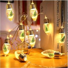 several light bulbs with plants inside them on a table