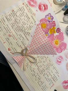 a piece of paper with flowers on it next to some scissors and other crafting supplies