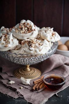 a glass bowl filled with meringue and nuts