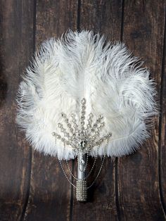 a white feather and crystal brooch on a wooden background