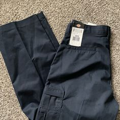 65% Polyester, 35% Cotton Twill Metal Buttons, Doubled Front Pocket Fabric, Reinforced Belt Loops & Crotch Ez-Touch Softened Fabric Relaxed Fit Stain-Release Cargo Pockets Accessed Via Concealed Zipper Closures Multi-Use Pocket Inside Left Cargo And Outside Right Cargo Blue Mid-rise Cargo Pants With Hip Pockets, Fitted Blue Cargo Pants, Fitted Blue Straight Leg Cargo Pants, Blue Utility Straight Leg Pants, Utility Style Blue Straight Leg Pants, Casual Navy Work Pants, Navy Mid-rise Pants With Pockets, Navy Mid-rise Casual Bottoms, Blue Mid-rise Bottoms With Side Pockets