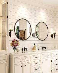 a bathroom with double sinks and mirrors on the wall