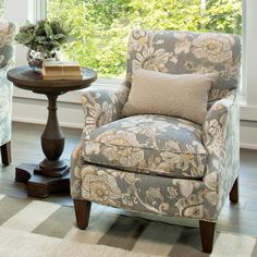 a chair and table in front of a window with trees outside the window sill