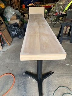 a wooden table sitting on top of a black metal stand