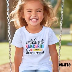 Gear up for the exciting journey ahead! Introducing our 'Watch out Kindergarten, Here I Come' custom name t-shirt, designed to make your little one's first day of school even more special. This back-to-school tee is perfect for capturing those unforgettable moments. Personalize it with your child's name and let them shine with confidence as they embark on this new chapter. Our unisex shirt for kids ensures a comfortable fit and is bound to become their favorite wardrobe staple. Get ready to celebrate this milestone with style Uplift any child's wardrobe with a custom kid's t-shirt. The Bella Canvas short sleeve tee for toddlers is a 100% Airlume combed and ring-spun cotton jersey with a tear-away label for extra comfort. Choose your favorite color out of a big variety, and make unique stap Funny T-shirt For End Of School Year, Personalized Short Sleeve T-shirt For Back To School, Fun Letter Print T-shirt For End Of School Year, Playful Back-to-school T-shirt For Playtime, Playful Back To School T-shirt, End Of School Year Fun T-shirt With Letter Print, Customizable T-shirt For Back To School Events, White T-shirt For Daycare, Casual T-shirt For Back To School Playtime