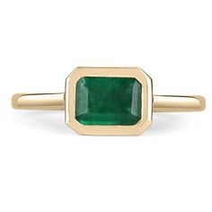 a gold ring with an emerald stone in the center and a thin band around it