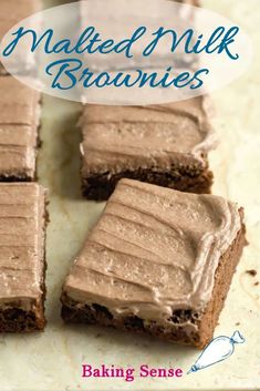 some brownies with frosting on them sitting on top of a counter next to a sign that says naked milk brownies