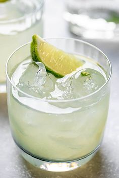 two glasses filled with ice and lime slices